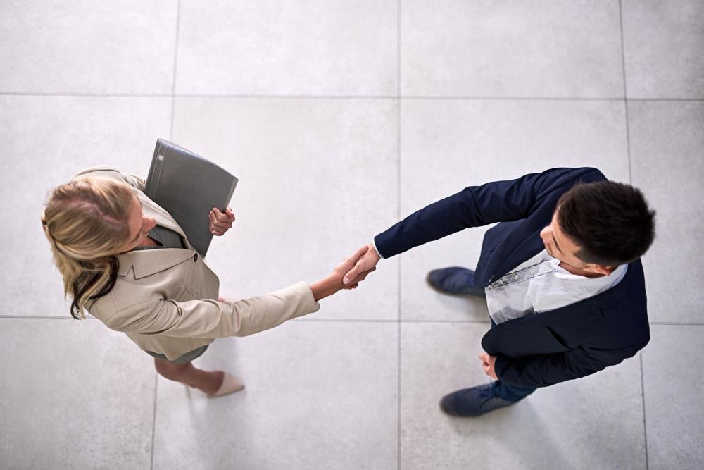 Apretón de manos entre dos profesionales, vista cenital
